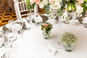 wedding table setting with flowers, cutlery and glasses