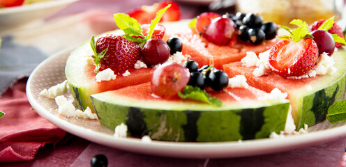 Fresh summer salad with berries and fruits on watermelon with feta cheese