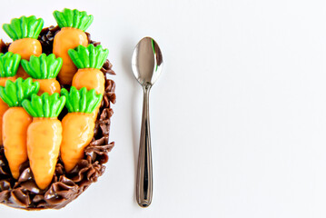 Delicious spoon egg stuffed with chocolate, Brazilian easter egg decorated with carrots on the white background.