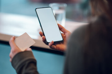Close up of a woman hands using smartphone and a credit card