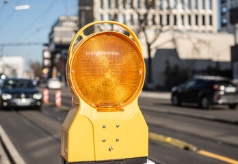 a yellow plastic warning sign in an urban street