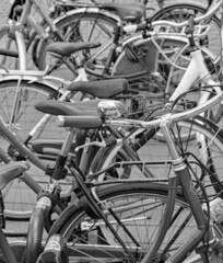 Fototapeta na wymiar A black and white closeup of a jumble of bicycles parked in Market Square, in Bruges, Belgium.