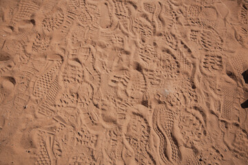 footprints of human shoes on red sand 