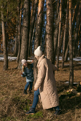 mom and daughter walk in the spring forest