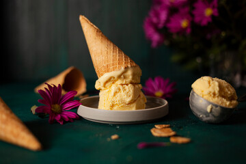 Passion fruit ice cream and pink flowers on green background