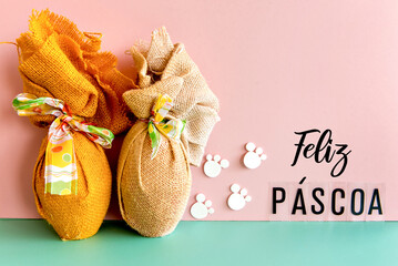 Easter concept, easter eggs decorated on pink and green background with (happy easter) written in Portuguese.