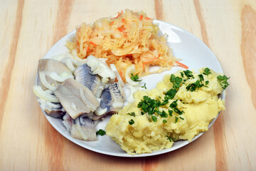 Herring with boiled potatoes, salad with parsleyn as polish traditional dinner