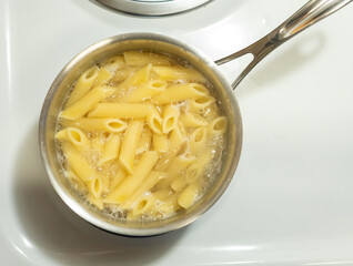A boiling pot of rigatoni pasta noodles 