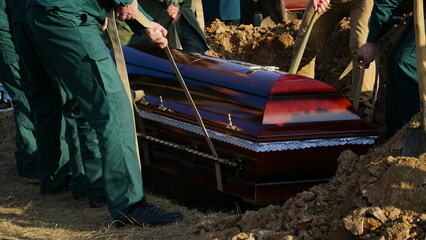 Religion, death and dolor - coffin bearer carrying casket at funeral to cemetery - obrazy, fototapety, plakaty