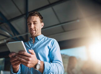 Business on the move. Cropped shot of a handsome young designer using his digital tablet in the office. © Delmaine D/peopleimages.com
