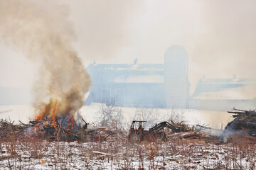 Tractor Moves Brush During a Controlled Burn on a Farm Property to Increase Arable Land