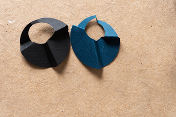 two 3d paper objects on plain brown paper