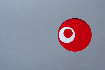 gray paper with red circle hole and white ring