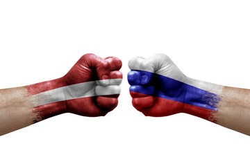 Two hands punch to each others on white background. Country flags painted fists, conflict crisis concept between latvia and russia - obrazy, fototapety, plakaty