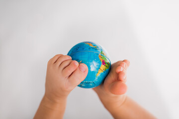 little baby legs hold the earth globe map on white background