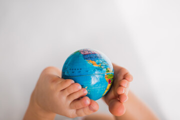 close up  earth globe map holding by baby legs on white background