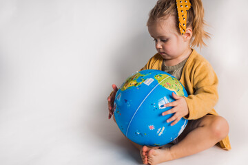 cute girl playing with inflatable globe world ball on white backgrounde