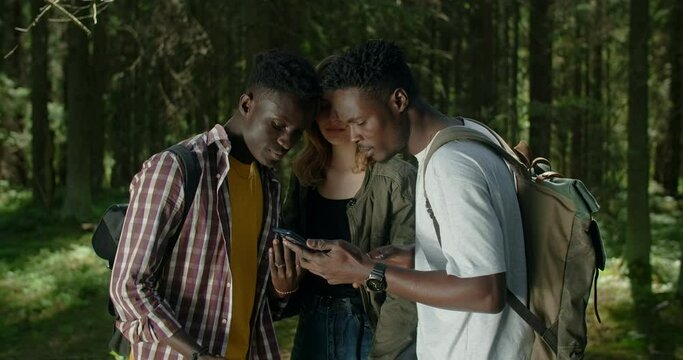 Multiracial tourists are using smartphone while trekking at hte forest, hiking in forest, 4k 60p Prores