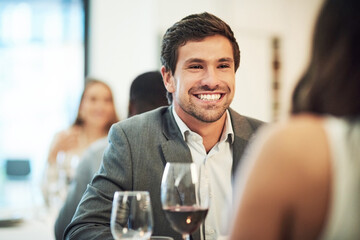 Hes head over heels. Cropped shot of an affectionate young man smiling broadly while on a date with his girlfriend in a restaurant.