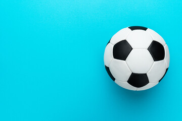 Fototapeta na wymiar Top view photo of white and black soccer ball as football concept . Minimalist flat lay image of leather football ball over blue turquoise background with copy space and right side composition.