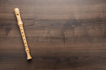 Overhead photo of block flute with copy space. Wooden recorder on the wooden background. - obrazy, fototapety, plakaty
