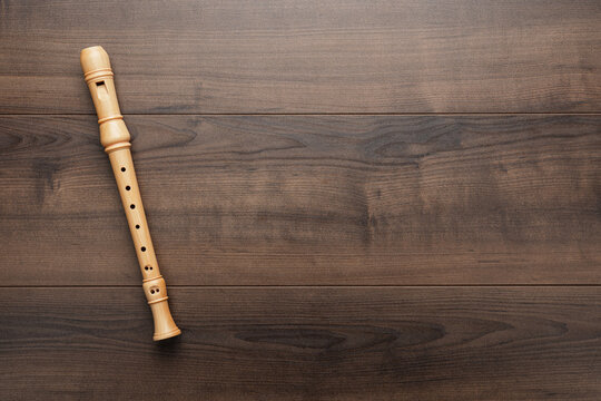 Overhead photo of block flute with copy space. Wooden recorder on the wooden background.