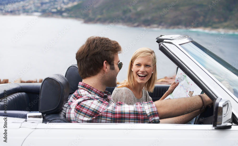 Poster Lets get driving. Shot of a young couple enjoying a drive along the coast in a convertible.