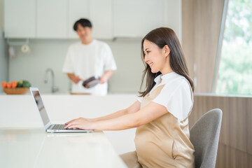 テレワークする妊婦と家事をする男性
