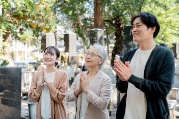 親子でお墓参りする（合掌）
