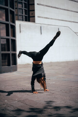 Woman doing advanced yoga outdoors in the urban area, side view. vertical photo