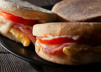 English muffin with egg ham tomato mayo and melted cheese macro photography.