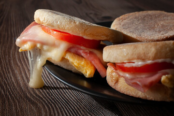 English muffin with egg ham tomato mayo and melted cheese macro photography.