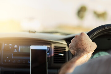 Driving to the next destination. Cropped shot of a unrecognizable man driving in a vehicle with his cellphone attached to the dashboard.