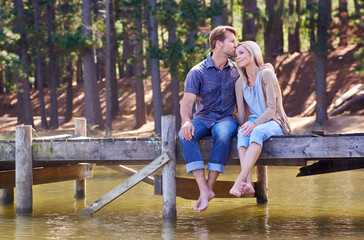 Sharing a romantic moment. A loving married couple enjoying a moment on the jetty at the lake.