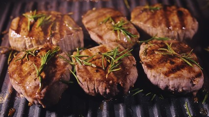 Delicious juicy meat steak cooking on grill. Aged prime rare roast grilling tenderloin fresh marble tenderness beef. Prime beef fry on electric roaster, rosemary, black pepper, salt. Slow motion.
