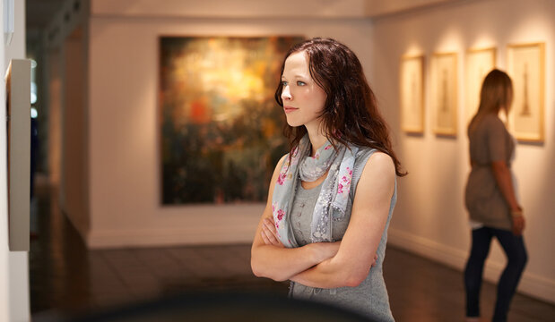 Examining the masters. Shot of a young woman looking at paintings in a gallery.