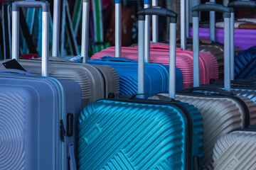 Bright  colorful rows of suitcases with extended handles and different sizes are on sale in front of the store