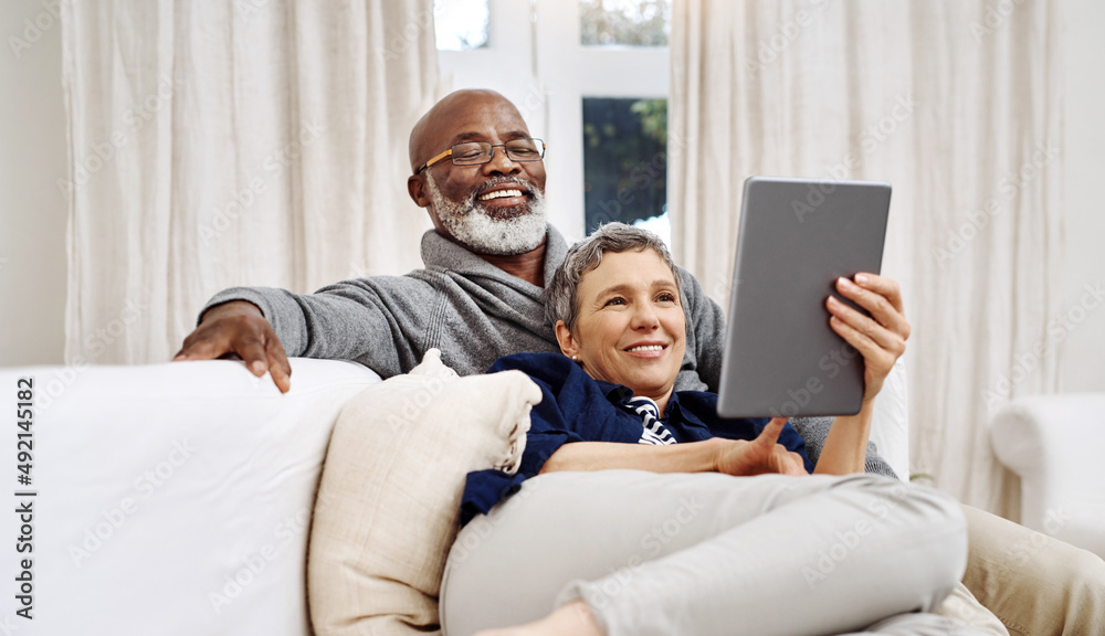 Aufkleber spending the day together at home. shot of an affectionate senior couple using a tablet while relaxi