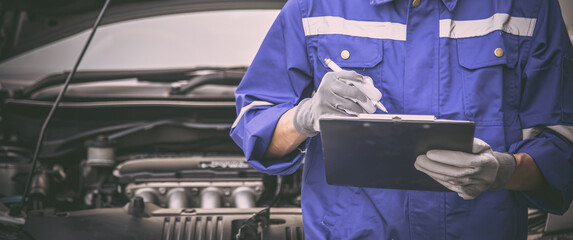 Car care maintenance and servicing, Close-up hand technician auto mechanic checking inspection list...