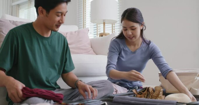Relax safe get away ready to get back to road trip. Asia people man woman choose clothing with love smile happy plan enjoy dating sit laugh fun folding stuff stack face mask open and neat bag at home.