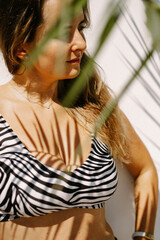 young beautiful woman in a swimsuit under a summer shower on the beach