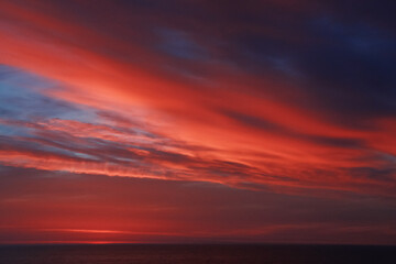 Naklejka na ściany i meble オレンジ色の雲がきれいな夕暮れの海 
