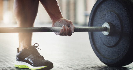 Lift with your legs. Cropped shot of an unrecognizable young man lifting weights in the gym.