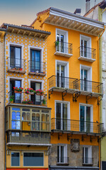 Colorful house facades and ornate metal balconies with flowers in the old town or Casco Viejo in Pamplona, Spain famous for running of the bulls