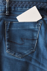 The upper part of old worn blue jeans with pockets and a white tag for clothes