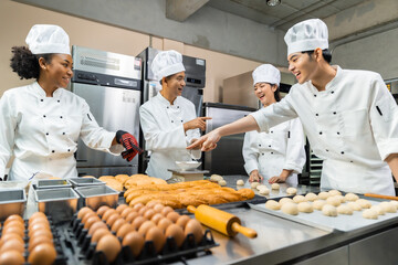 Asian Chefs  baker in a chef dress and hat, cooking together in kitchen.Team of professional cooks...