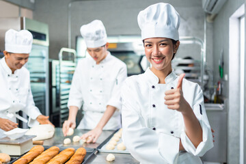 Smiling  asian  female bakers looking at camera..Chefs  baker in a chef dress and hat, cooking...