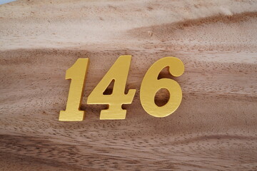 Golden Arabic numerals on real wood with brown and white pattern.