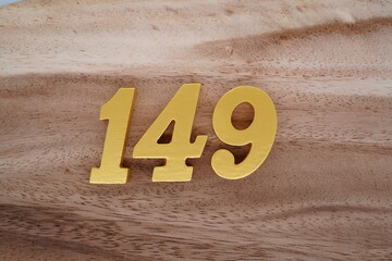 Golden Arabic numerals on real wood with brown and white pattern.