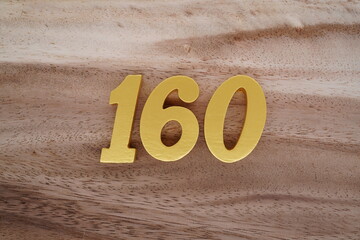 Golden Arabic numerals on real wood with brown and white pattern.